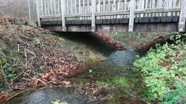 Stream flowing under the wooden bridge