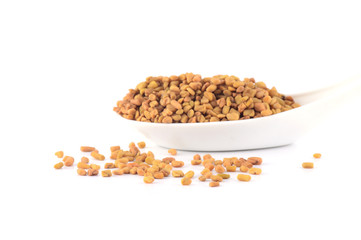fenugreek seeds in spoon isolated on white background