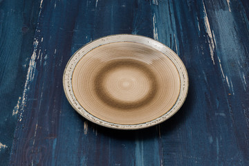 Plate on blue wooden background side view