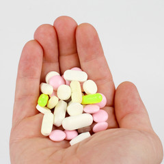 different medical tablets in the palm of your hand