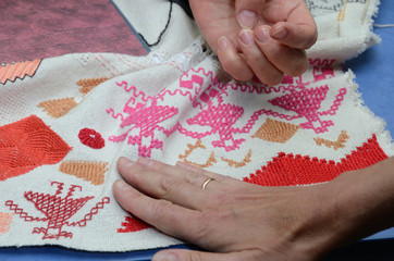 Female hands on the cloth with embroidery