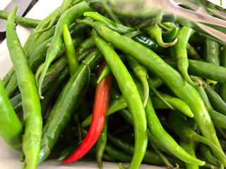 Red and green hot peppers on a buffet. Horizontal, close-up, side view. Food and health concept.
