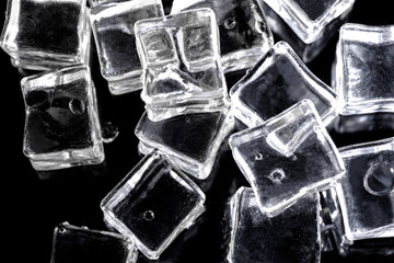 Ice cube. Close up transparent light ice cubes on black background. Macro horizontal photography.