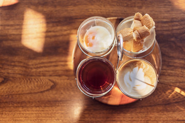 Vintage hot coffee set with soft boiled eggs and toasted sticks on wooden table in morning sunlight