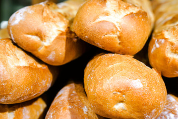 Pile of French bread on shelf in bakery.