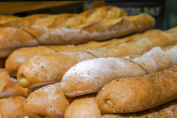 French bread line up on shelf in bakery.