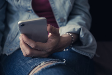using cell phone.hand holding texting message on screen mobile chatting friend ,search internet information sitting on sofa in office.technology device contact communication connecting people concept