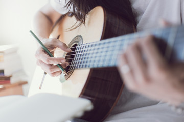 Fototapeta premium artist songwriter thinking writing notes,lyrics in book at studio.man playing live acoustic guitar relax chill.concept for musician creative.composer work process.people relaxing time with instrument