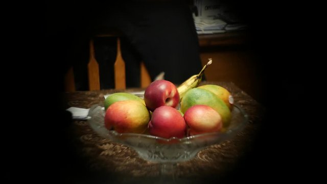 Super creative shot of a bowl of fruit on a table, with apples, banana and mango