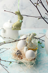 Easter scene with spring fresh greenery branches, rabbit and box of eggs, springtime festive background