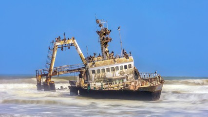 A long exposure shot of a fishing trawler shipwrecked on the Skeleton Coast of Namibia, covered...