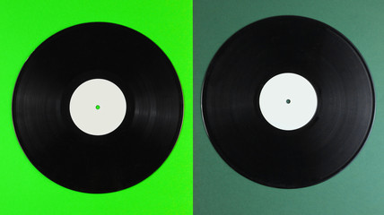 Two vinyl records on a green background. Retro style. Top view.