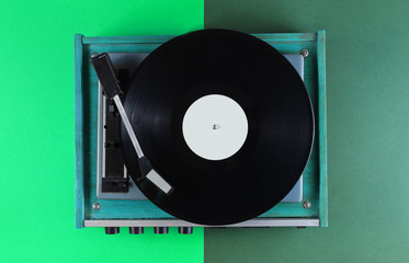 Retro vinyl record player on green background