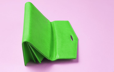 Upside down green leather wallet on pink background