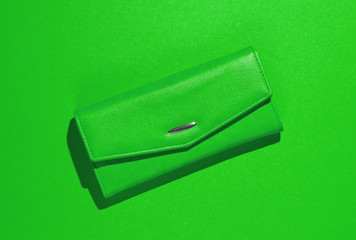 Fashionable leather wallet on green background. Top view