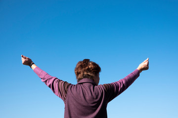 両手を広げるシニア女性