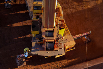 Top view of crane operator wearing safety hard hat visible T-shirt conducting daily safety...
