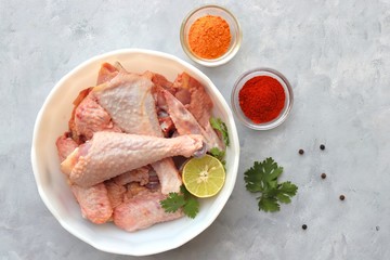Clean and Raw Free range or country chicken carved in parts in a bowl with Indian spices and cooking ingredients. Along with copy space