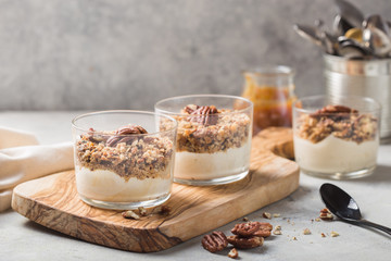 Delicious natural yogurt parfait with caramel, pecan nuts on conctere background