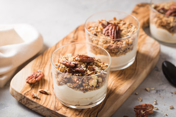 Delicious natural yogurt parfait with caramel, pecan nuts on conctere background