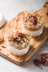 Delicious natural yogurt parfait with caramel, pecan nuts on conctere background