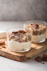 Delicious natural yogurt parfait with caramel, pecan nuts on conctere background