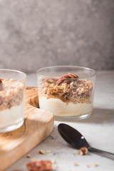 Delicious natural yogurt parfait with caramel, pecan nuts on conctere background