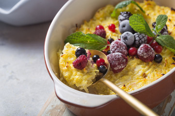 Cottage cheese casserole baked with  with fresh berries on kitchen table.