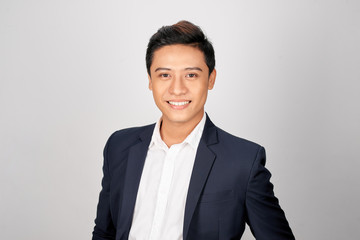 Young good looking asian business man on a white background isolated