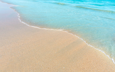 Brown sand beach and small wave of blue water in the sea