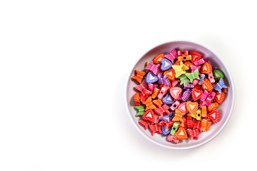 Colorful beads in the shape of butterflies and hearts shot large on a white background