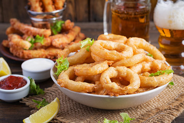 Onion rings in batter with sauce and cheese sticks. Beer snacks. Copy space