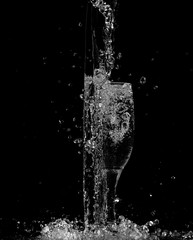 Obraz na płótnie Canvas splash and spatter of water in a glass on a black background