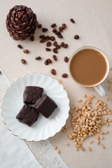 Rich winter hot chocolate with cinnamon sticks and walnuts in blue enamel mug on wooden board over grey concrete background, selective focus, square crop