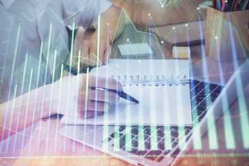 Financial charts displayed on woman's hand taking notes background. Concept of research. Double exposure