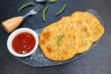 Freshly fried Masala stuffed Aloo puri or Kachori served hot with tomato ketchup and Green chilies