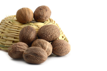 Nutmeg in bamboo basket isolated on white background