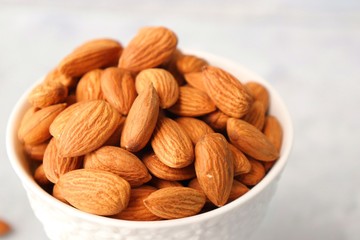 Almonds in white bowl on table. Almond Food or ingredient concept with copy space