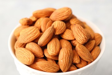 Almonds in white bowl on table. Almond Food or ingredient concept with copy space