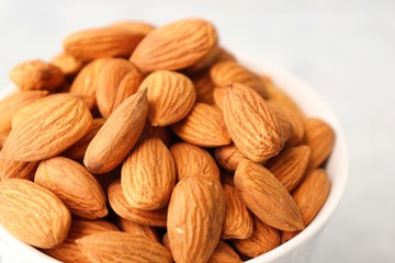 Almonds in white bowl on table. Almond Food or ingredient concept with copy space