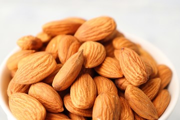 Almonds in white bowl on table. Almond Food or ingredient concept with copy space
