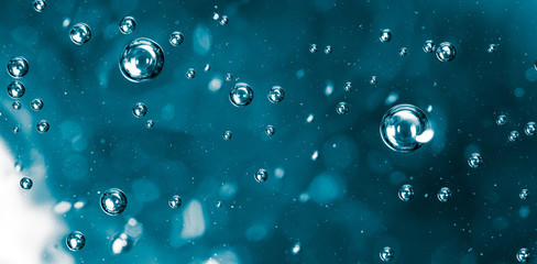 Bubbles of air on the smooth surface of blue water as an abstract background