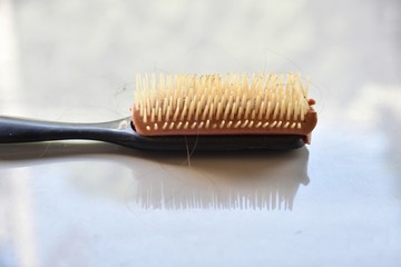 old hair comb plastic with hair on the floor