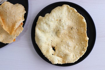 Indian crunchy fried snack papad or Papadam made of rice floor served in a plate. Also known as khichiya Papad.