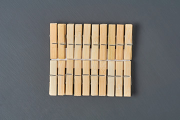Set of wooden clothespins lies on dark concrete desk in bathroom. Top view. Close-up