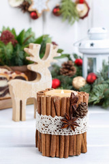 Candle decorated with cinnamon sticks, christmas decoration.