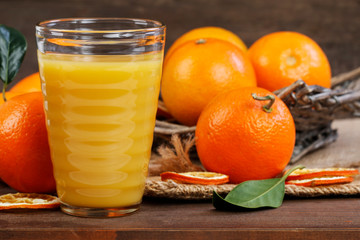 A glass of orange juice and the fresh fruits on wooden table.