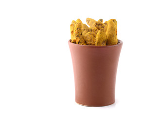 Dry Turmeric roots or barks in clay pot isolated on white background