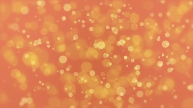 Glowing golden orange bokeh background with moving light particles.