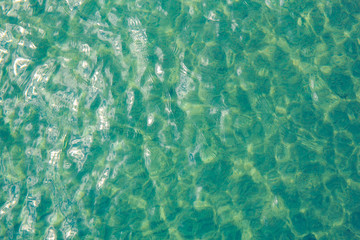 Sun light reflecting or sparkling glitter on water of sea or ocean.